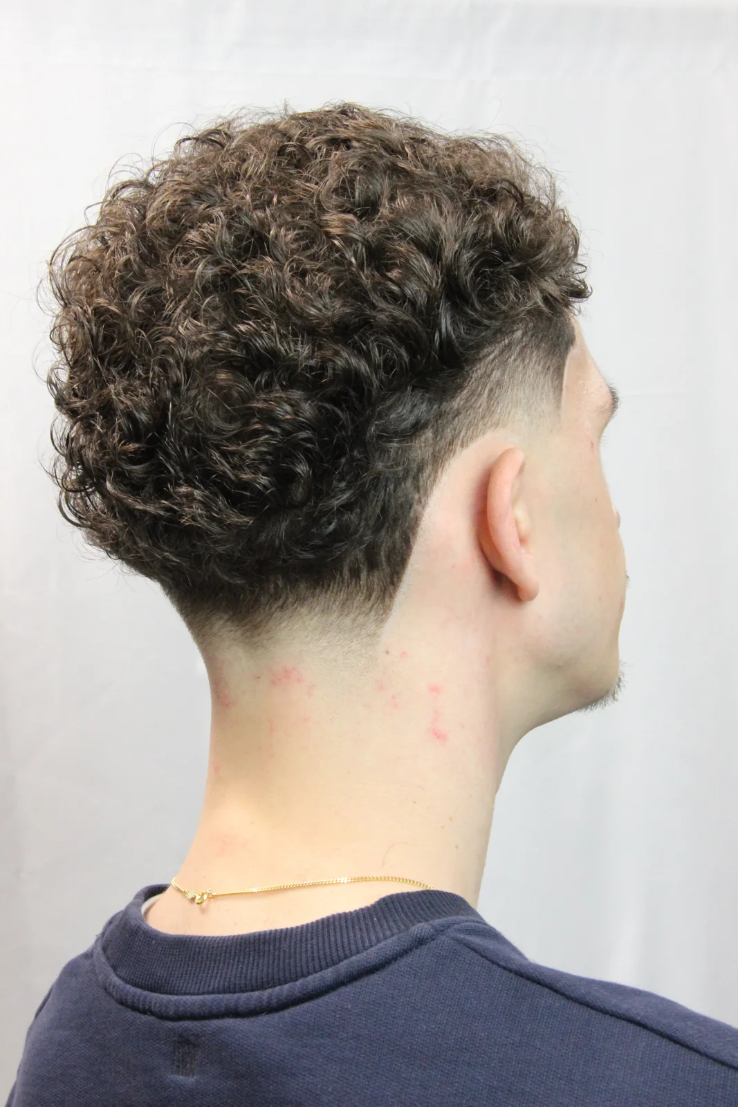 Une nuque dégagée sous le volume naturel des boucles.