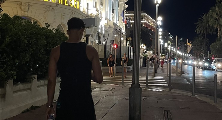 Mehdi de dos dans une rue éclairée en soirée